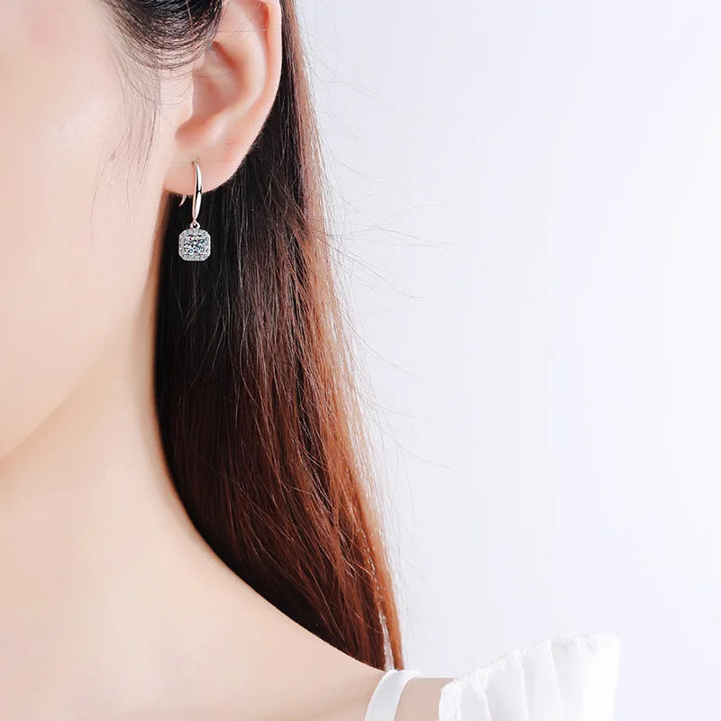 silver moissanite earrings elegant drop earrings with a larger moissanite stone in the middle and smaller moissanites on the sides moissanite for a refined look