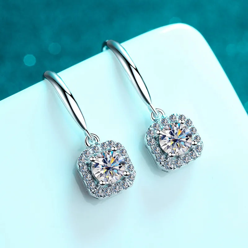 silver moissanite earrings transformed into drop earrings with a larger stone in the middle and smaller on the sides gram moissanite for a polished finish